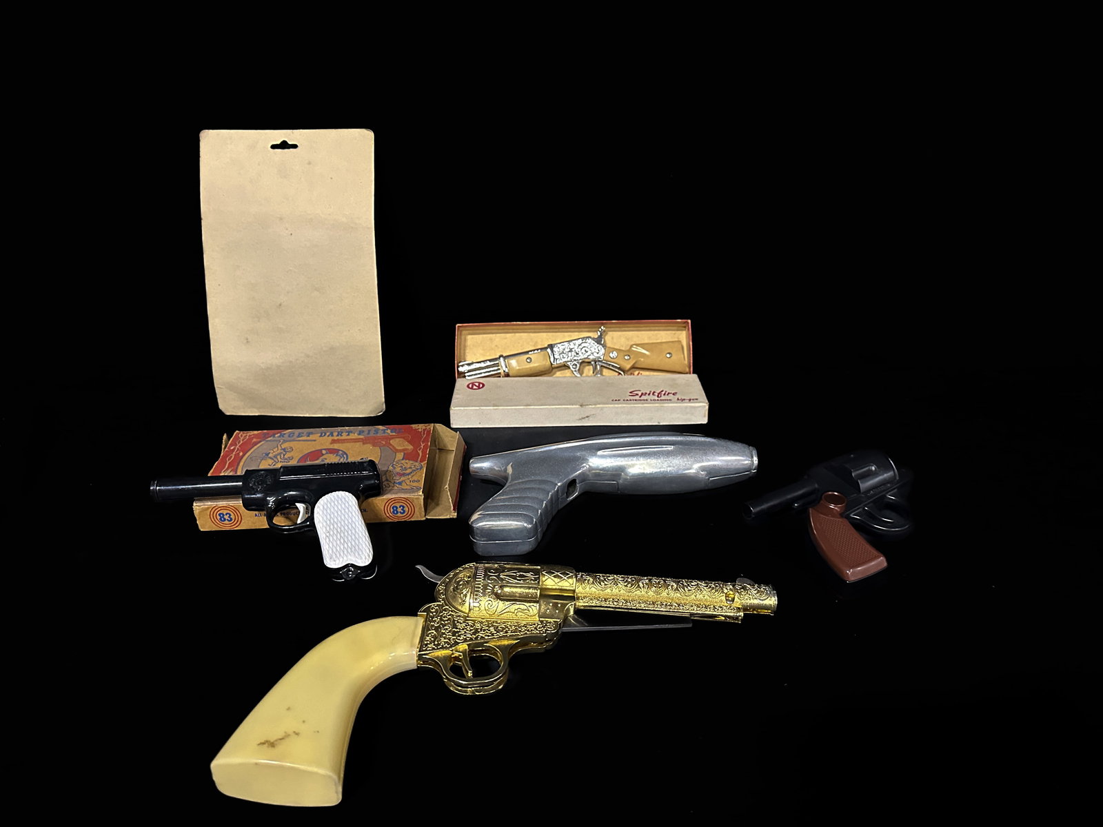 007 Cap gun Target dart pistol Spitfire Solitaire Golden Gun knife: Mixed lot of cap guns. PLEASE NOTE, THERE IS ONLY ONE WAY TO PAY FOR ONLINE ITEMS IN THIS AUCTION WHICH IS THROUGH LIVE AUCTIONEERS. THIS IS THE MOST SECURE METHOD OF PAYMENT. MAKE SURE YOUR LIVE AUCT