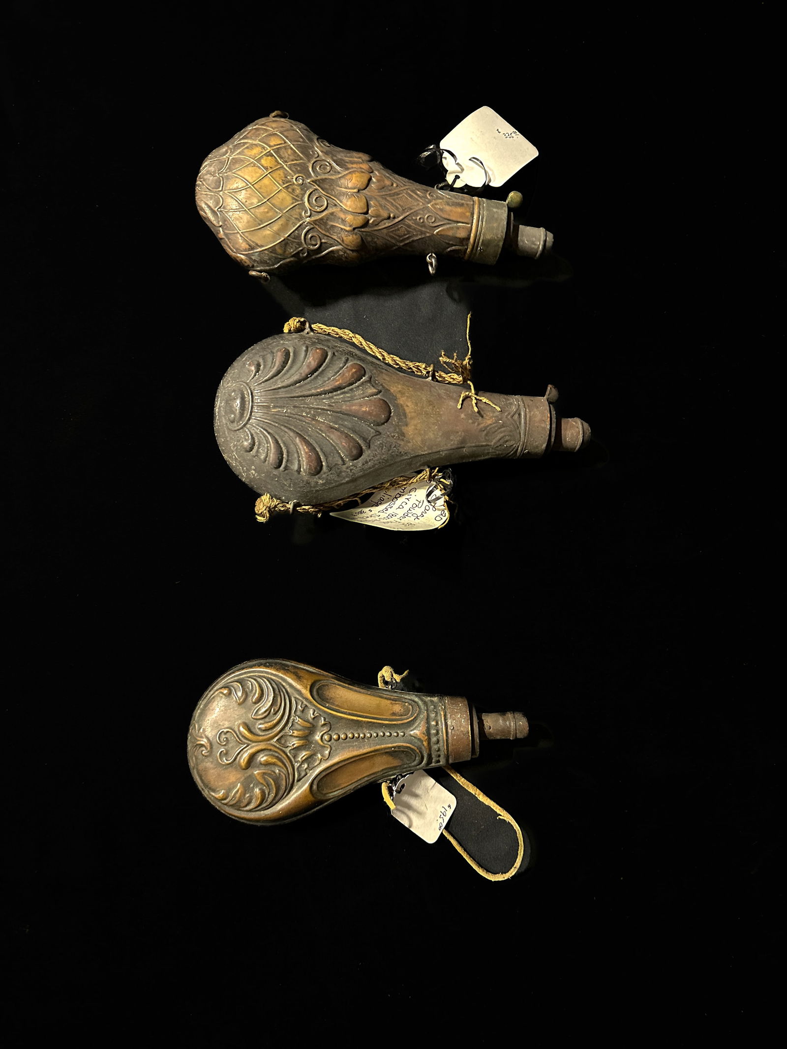 Embossed powder flask. 7" 8" versions. Embossed shell. Believed to be copper flasks (1 of 2)