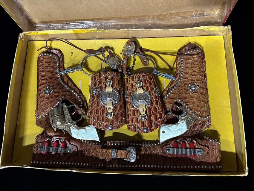 Gene Autry complete cap gun set with holsters, wrist guards, belt and spurs: In incorrect box. Complete Gene Autry cap gun set with holsters. PLEASE NOTE, THERE IS ONLY ONE WAY TO PAY FOR ONLINE ITEMS IN THIS AUCTION WHICH IS THROUGH LIVE AUCTIONEERS. THIS IS THE MOST SECURE M
