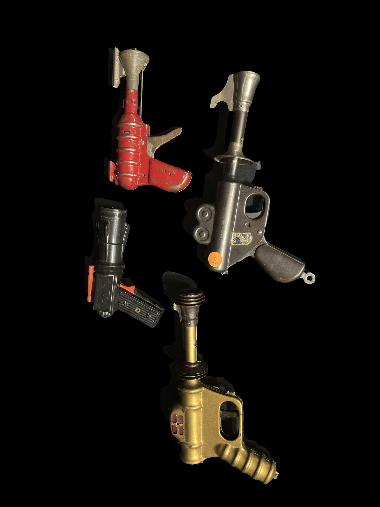 Assortment of toy metal guns including buck rogers atomic pistol sonic ray: Lot of 4 toy metal guns. Red and gold are functioning. PLEASE NOTE, THERE IS ONLY ONE WAY TO PAY FOR ONLINE ITEMS IN THIS AUCTION WHICH IS THROUGH LIVE AUCTIONEERS. THIS IS THE MOST SECURE METHOD OF P
