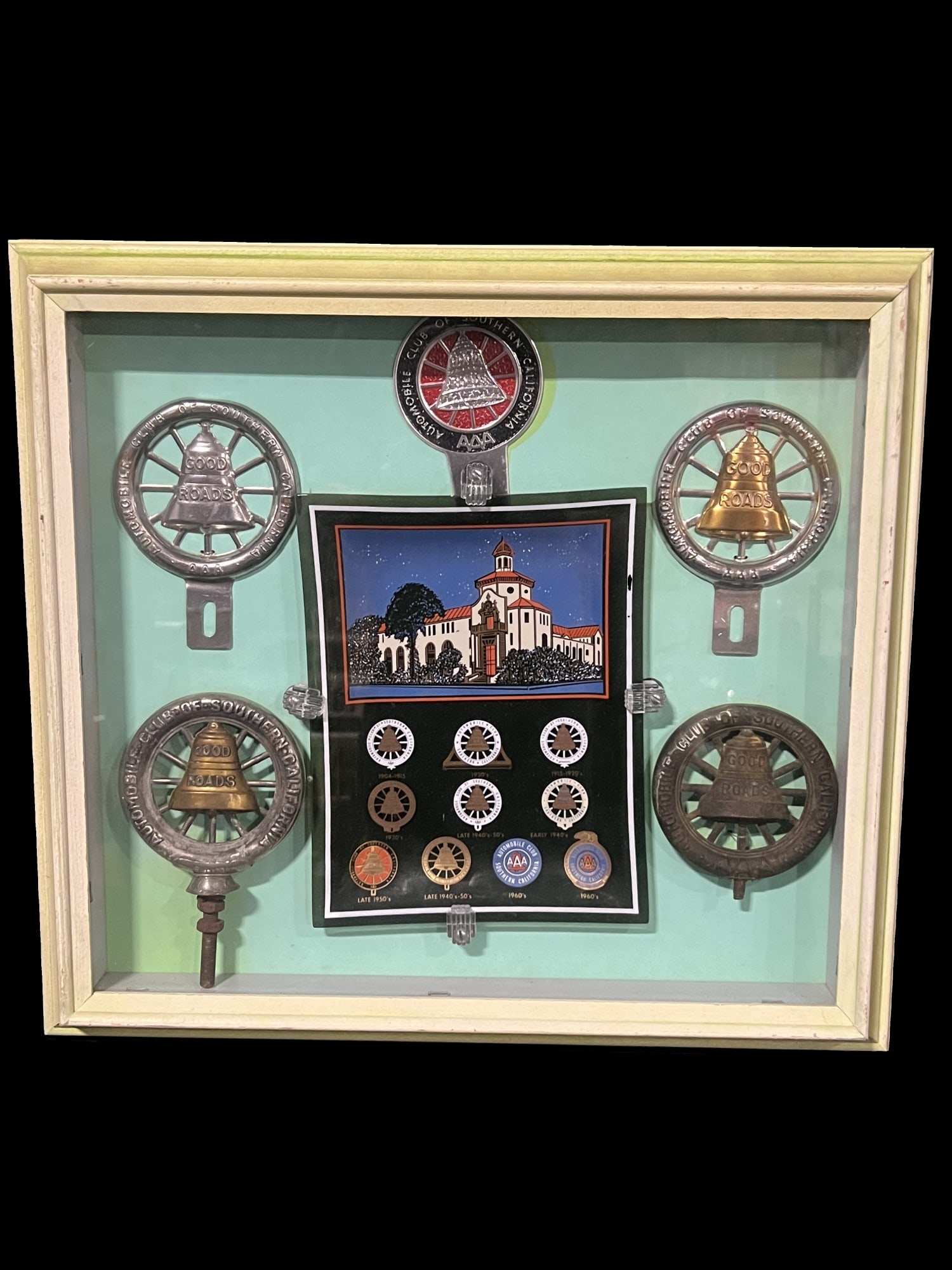 Automobile club of America AAA hood ornament license plate topper advertising: A group of license toppers and hood/radiator ornaments from Automobile Club of Southern California with a plate showing the change in the AAA logo over the decades. PLEASE NOTE, THERE IS ONLY ONE WAY 