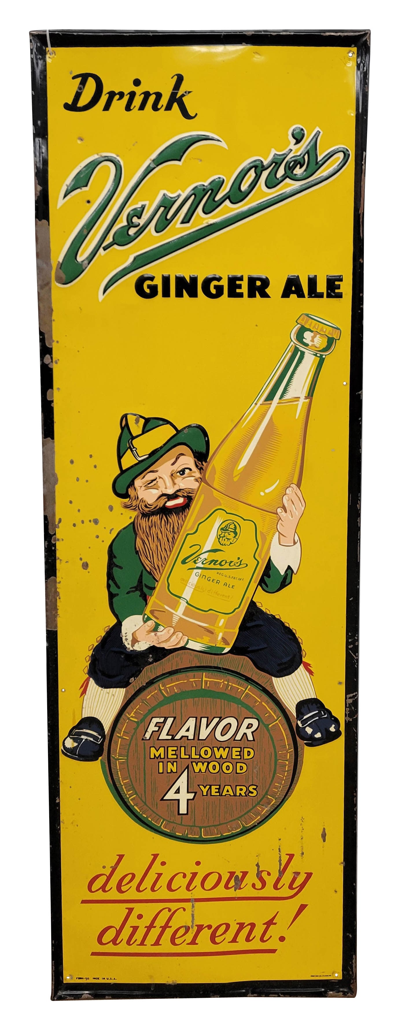 Drink Vernor's Ginger Ale Deliciously Different Embossed Single Sided Tin Sign TAC: 18" x 55" embossed SST sign showcases the brand's iconic gnome mascot holding a large Vernor's bottle while perched atop a barrel that states "Flavor Mellowed In Wood 4 Years". The sign displays good