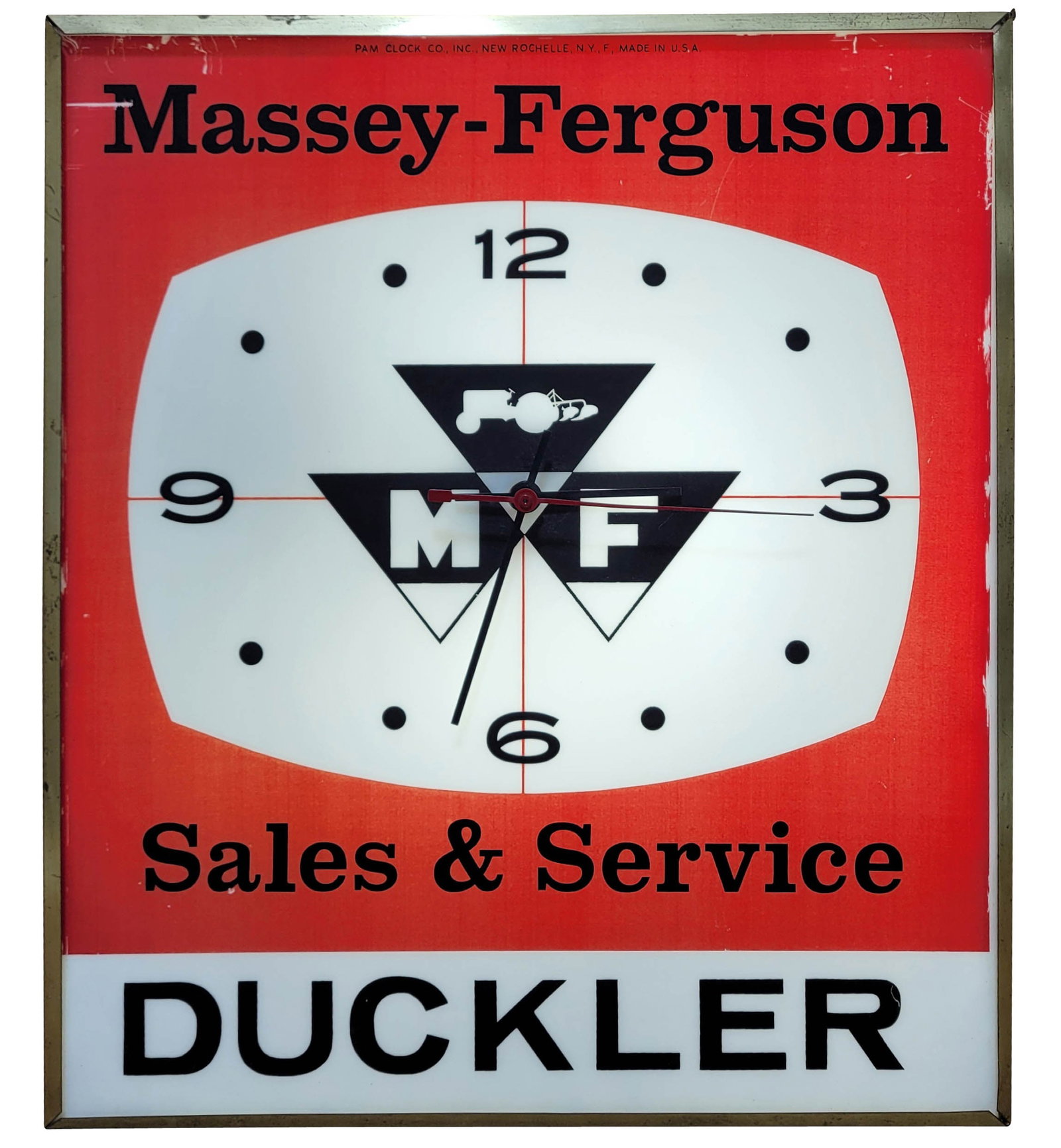 Massey Ferguson Sales and Service Duckler Light Up Pam Clock: 15" x 18" working illuminated clock features a plastic advertising face with good color and light scratches in the field and around the perimeter. The clock has gold trim and metal housing that displa