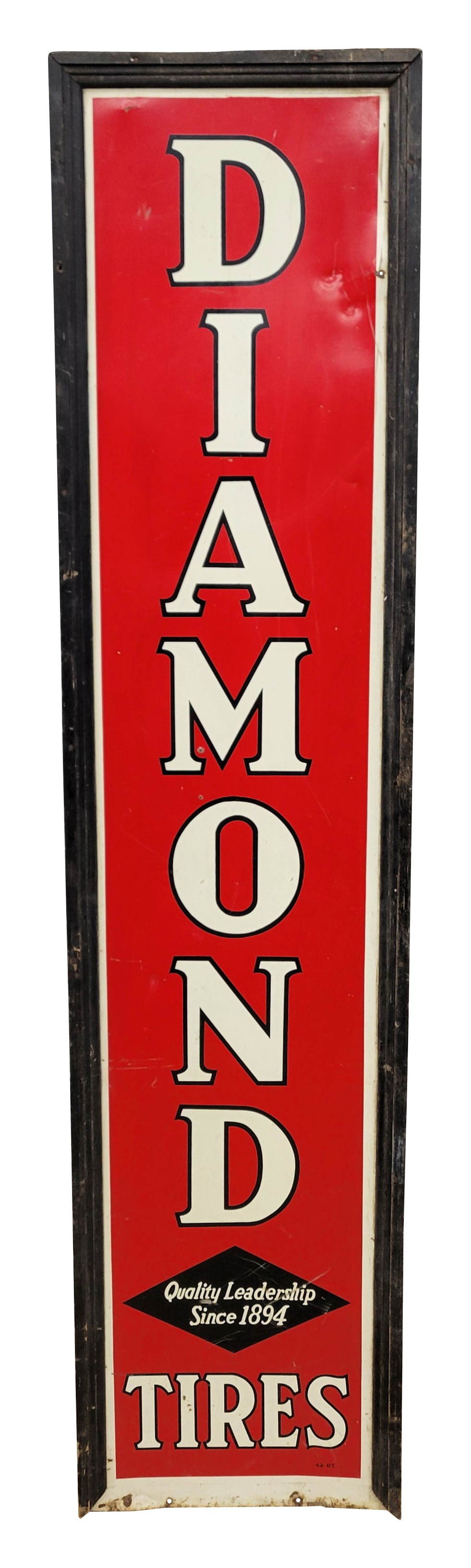 Diamond Tires Single Sided Tin Sign In Wood Frame: 18" x 78" SST sign is encased in a wood frame. The sign exhibits good color with wear?in the field including scratches, dings, and small holes. The wood frame shows wear with faded paint and a piece i