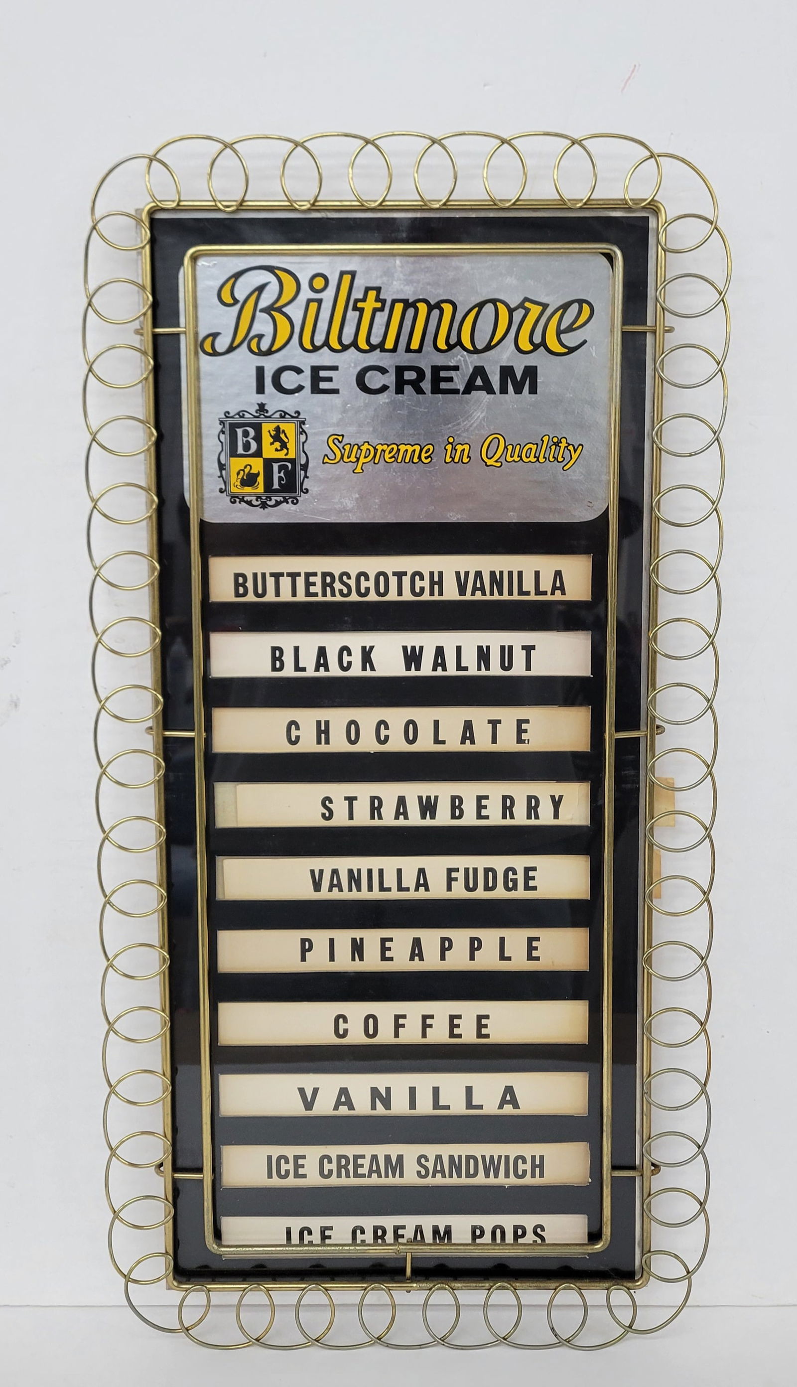 Biltmore Ice Cream Supreme In Quality Menu Board: 12.25" x 24.5" cardboard menu board comes complete with inserts. It is framed under plexiglass and features an ornate metal decorative frame. The cardboard beneath the plexiglass remains in good condi