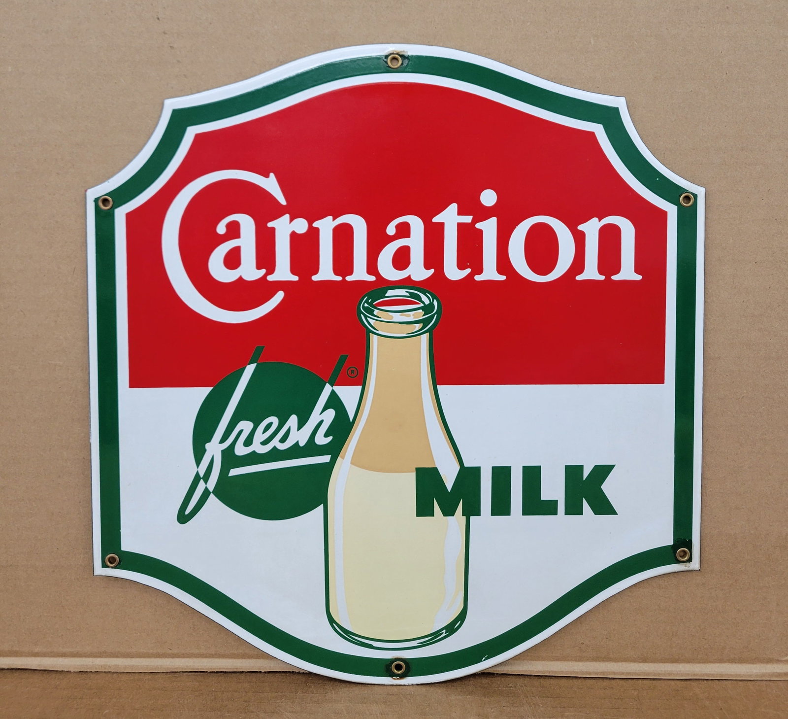 Carnation Fresh Milk Single Sided Porcelain Sign: 14.25" x 15" single sided porcelain sign exhibits vibrant colors and high gloss. Several of the mount holes have small color matched chips present. The sign displays very well overall. Rated 9.0.