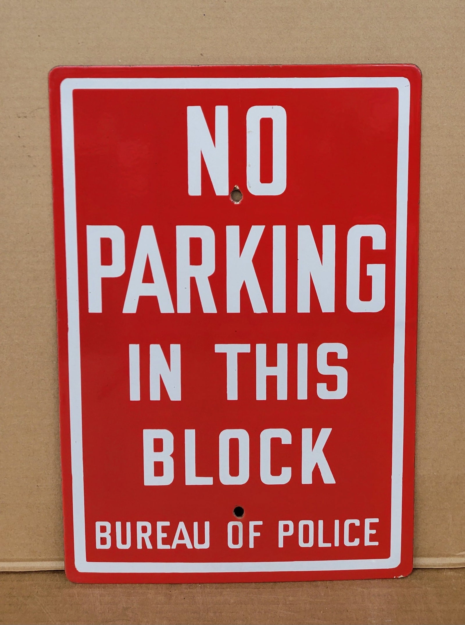 No Parking In This Block Bureau Of Police Single Sided Porcelain Sign: 12" x 18" SSP sign is in excellent condition exhibiting bright colors and high gloss with minor scuffs. There are 2 mounting holes in the center.