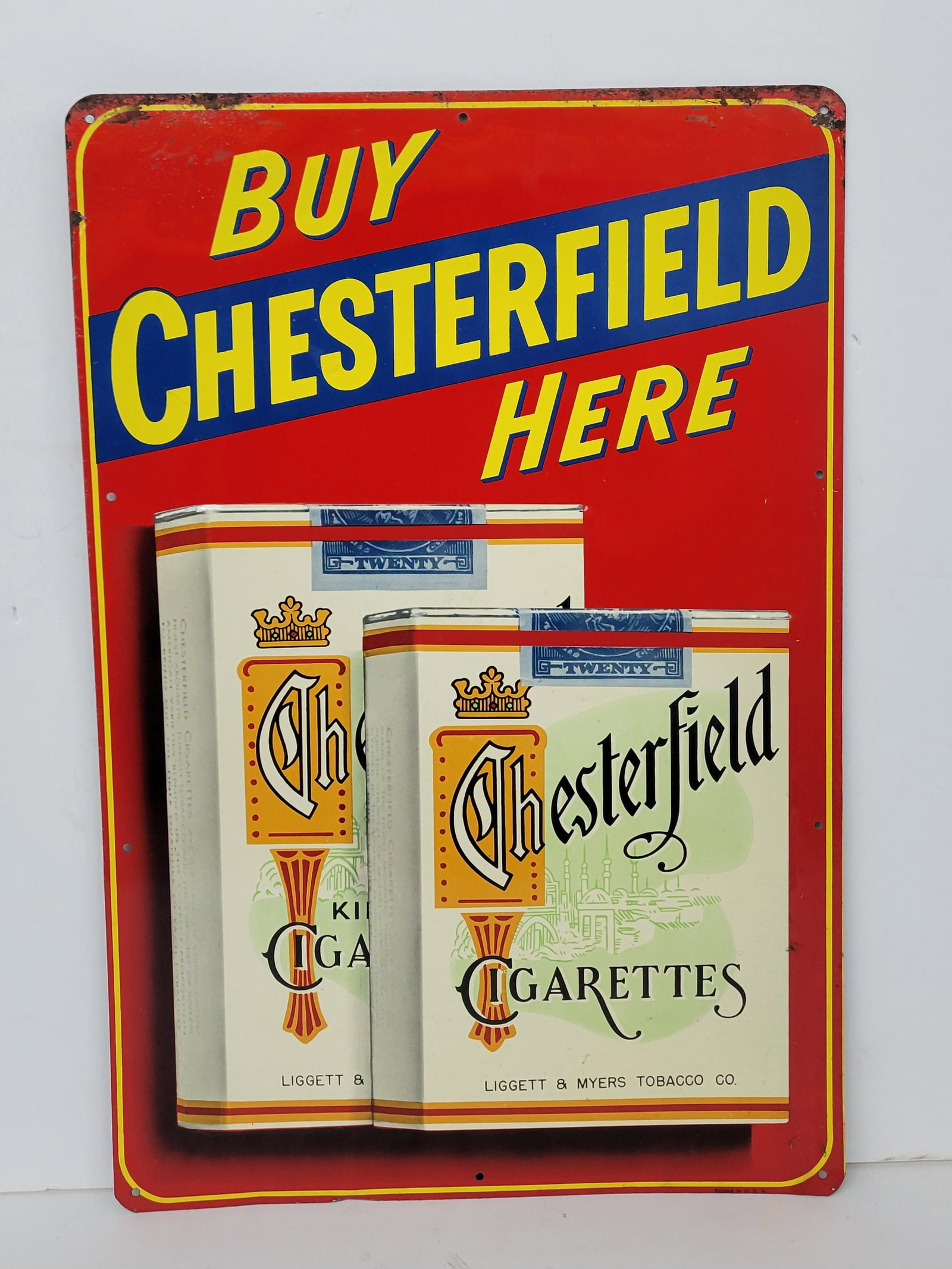 Buy Chesterfield Here Single Sided Tin Sign: 11.75" x 17.75" SST sign has excellent color with light scuffs in the field. The perimeter has areas of bubbled paint with wear, paint flakes and light surface rust.