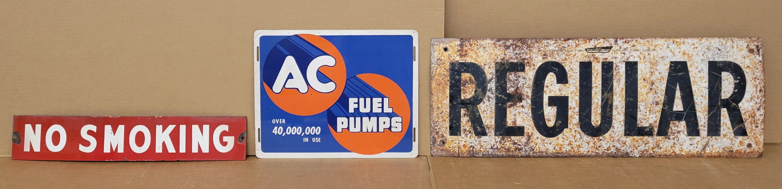 No Smoking, AC Fuel Pumps, and Regular Signs: Lot of 3 signs includes a 21" x 4" SSP NO SMOKING sign in good condition, a 15" x 12" SST AC Fuel Pumps sign in good condition, and a 30" x 11" SST REGULAR sign with heavy wear and rust.