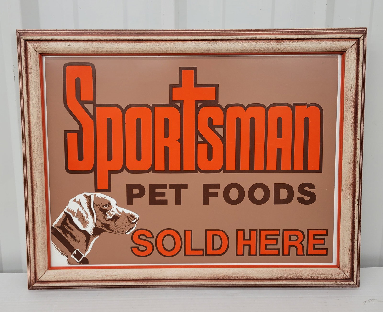 Sportsman Pet Foods Sold Here Framed Single Sided Tin Sign: 28"x 21" professionally framed sign has excellent color. There are a few minor dings and scuffs. The frame is wood and has a vintage look. The piece displays well overall.