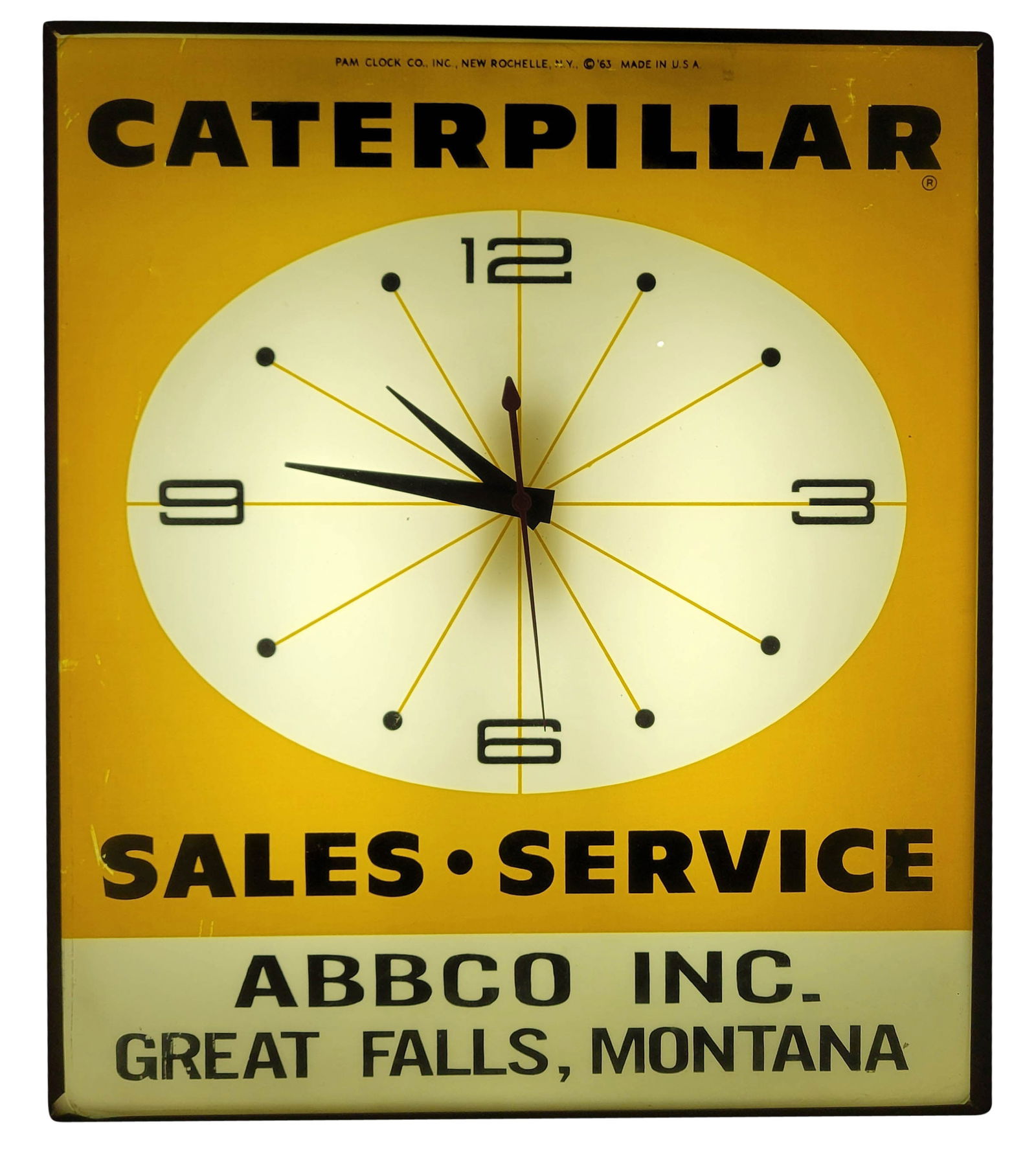 1963 Caterpillar Sales and Service Great Falls Montana Light Up Pam Clock: 15" x 18" x 4" working illuminated clock with a glass face displays bright colors with a few fine scratches on the inner clock face. The outer metal housing has light signs of wear.