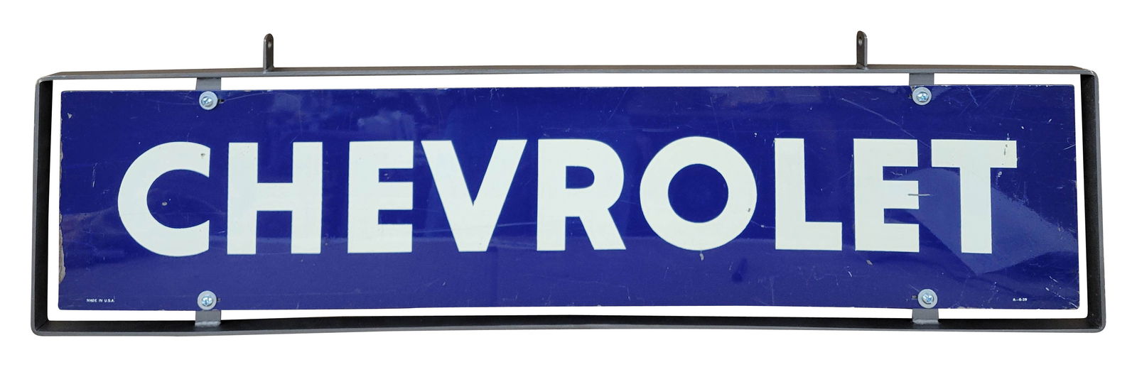 Chevrolet Double Sided Tin Sign In Frame: 41.5" x 12" SST sign has been mounted inside a new metal frame. The sign showcases good color and shine, with noticeable wear on each side, including scratches and paint flaking along one edge. The ne