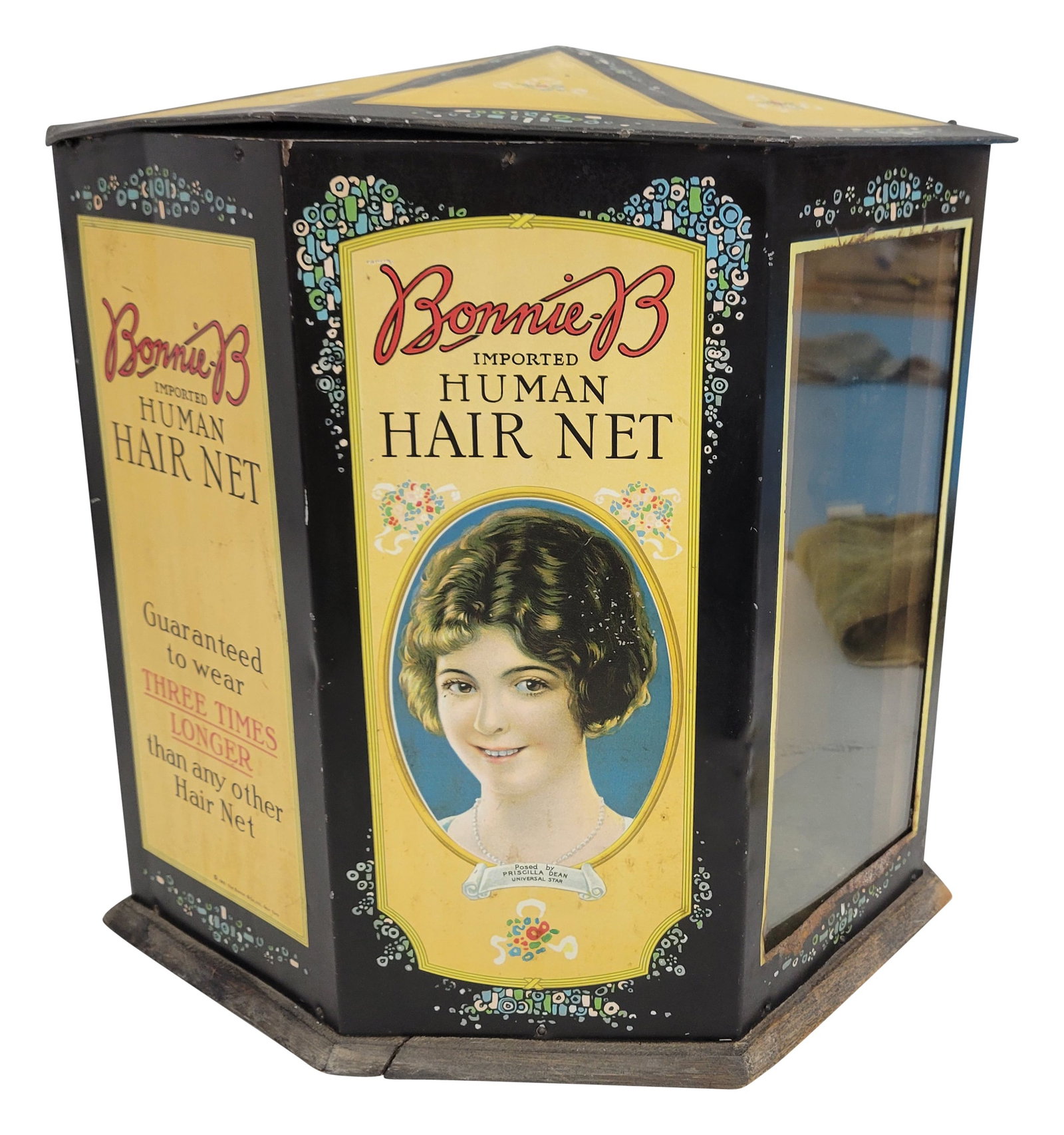1921 Bonnie's Imported Human Hair Net Counter Top Cabinet Display: 13" x 13.5" x 10.5" metal display cabinet features a glass viewing window, vibrant Victorian graphics, and a wooden base. Originally, the glass window was a mirror. The cabinet shows moderate signs of