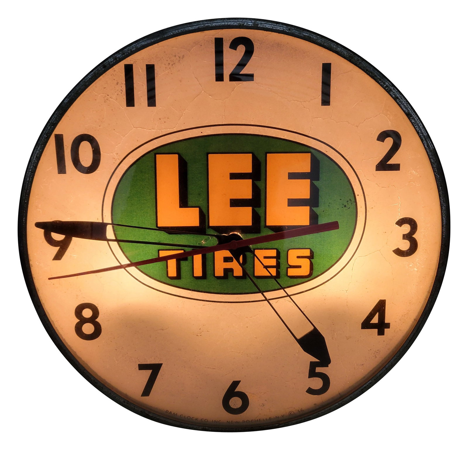 Lee Tires Light Up Pam Advertising Clock: 15" working illuminated clock features a glass clock face, metal trim, and a metal can. The inner advertising face has good color on the logo with crackling in the paint throughout the surface. The