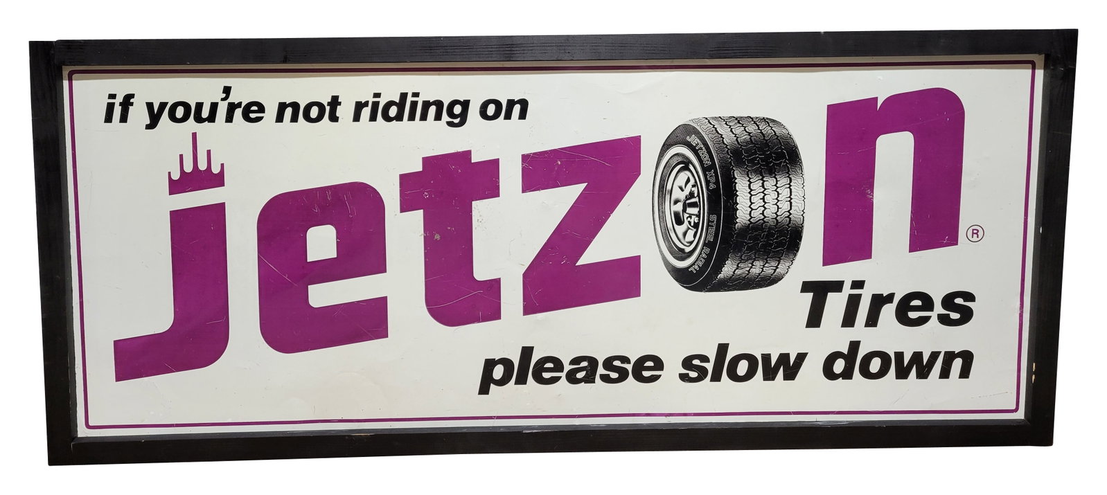 Jetzon Tires Single Sided Tin Sign: 62" x 26" SST sign displays moderate wear throughout with scratches and small dings. The sign is attached with screws to a painted wood frame. The frame is in good condition with a few small nicks in
