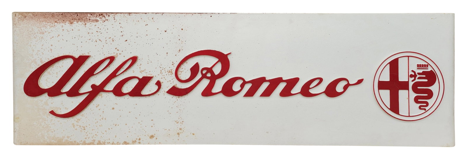 Alpha Romeo Embossed Sign: 60" x 18" single sided compressed synthetic construction sign features the Alfa Romeo name and logo. There are speckled discolorations and stains on the front of the sign and around the perimeter. The