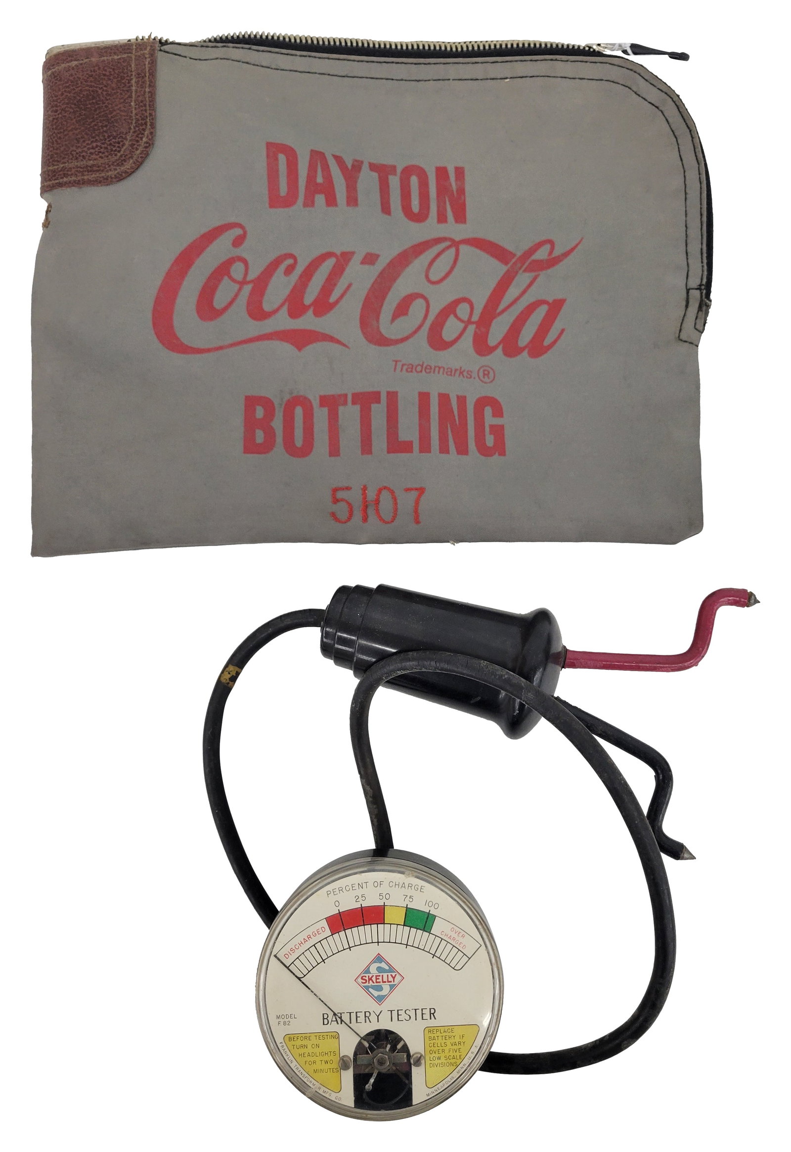 Skelly Battery Tester and Dayton Coca Cola Bottling Plant Bank Bag: Lot of 2 includes a Franklin Transformer Skelly Battery tester in good condition with a small crack on the plastic gauge face. Working condition is unknown. Also included is a Coca Cola bank bag from 