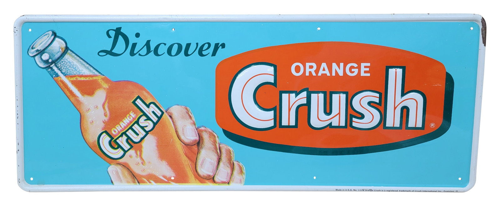 Discover Orange Crush Embossed SST Sign: 30" x 11.75" single-sided tin sign showcases embossed lettering that reads "Crush." The sign exhibits impressive color and shine, although it does have a few very minor scratches on the surface. The s