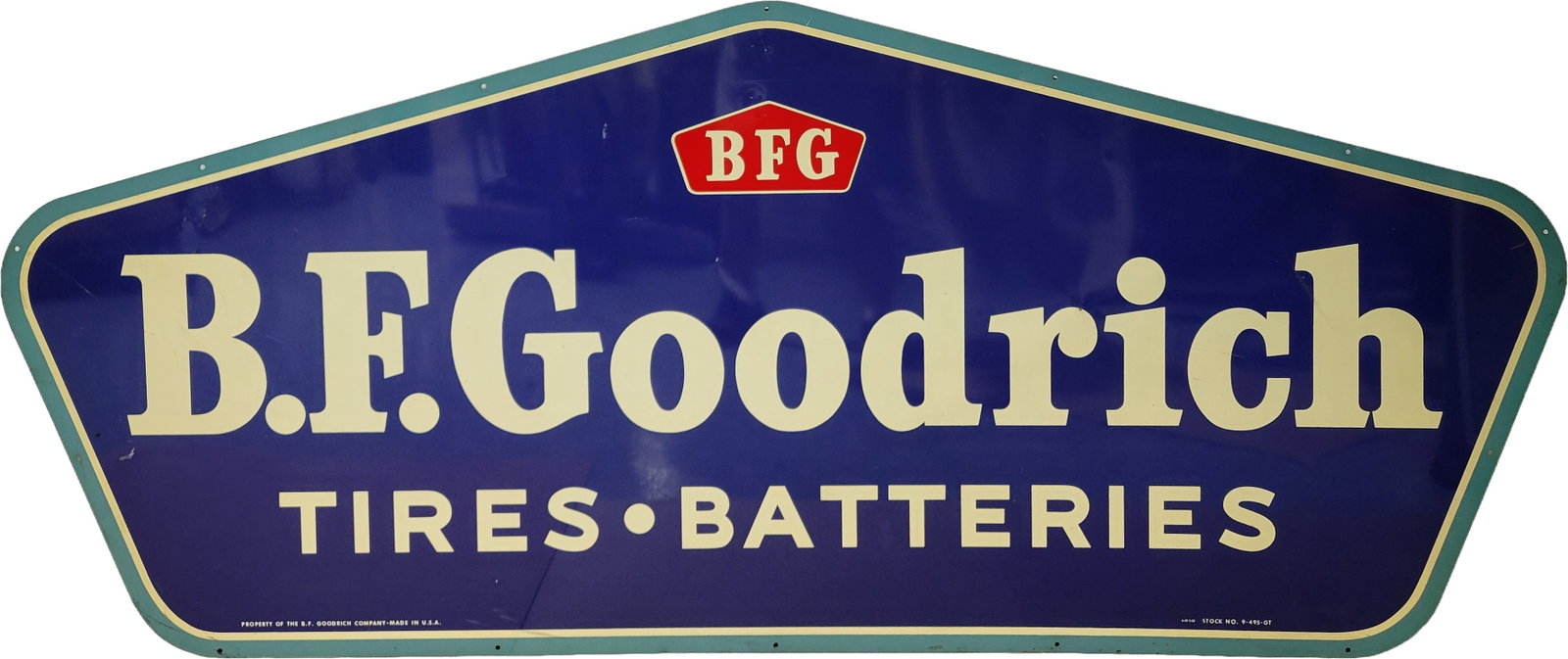 B.F. Goodrich Tires and Batteries SST Sign: 83" x 36" single sided tin sign displays excellent color and shine with light wear in the field including several small scratches and dings. The perimeter has minimal wear. Property Of The B.F. Goodri