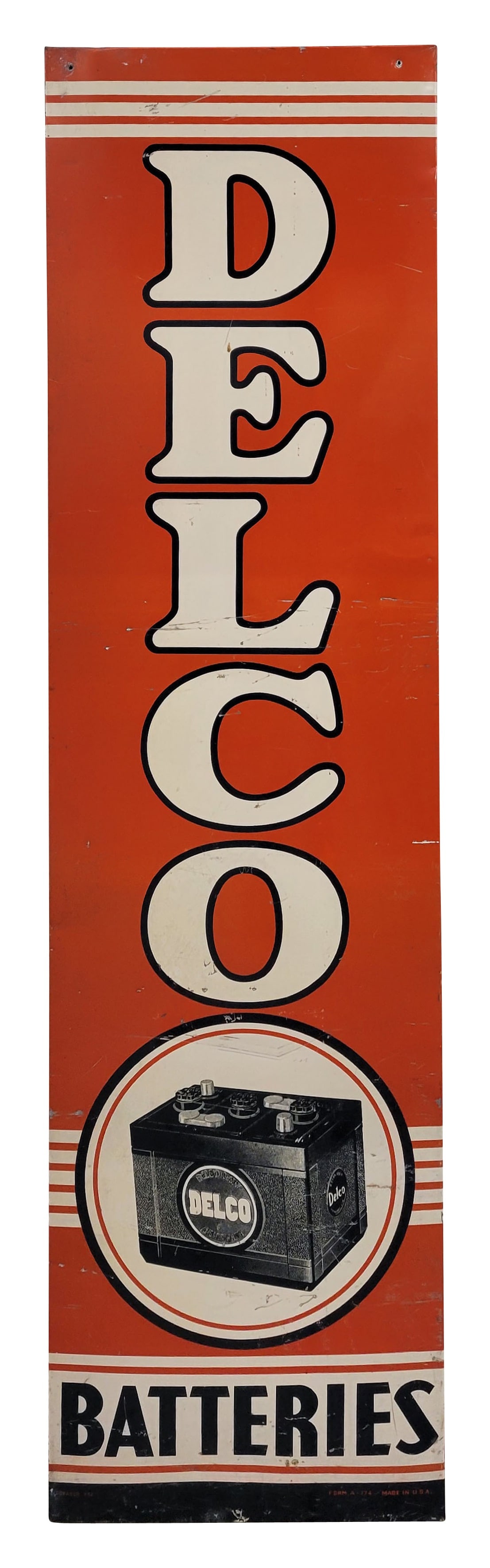 Delco Batteries Single Sided Tin Sign: 18.5" x 70.5" vertical SST sign exhibits general wear throughout with deep scratches, small dings, and wear around the perimeter. The sign has a wood frame on the back. Donasco 7-52.