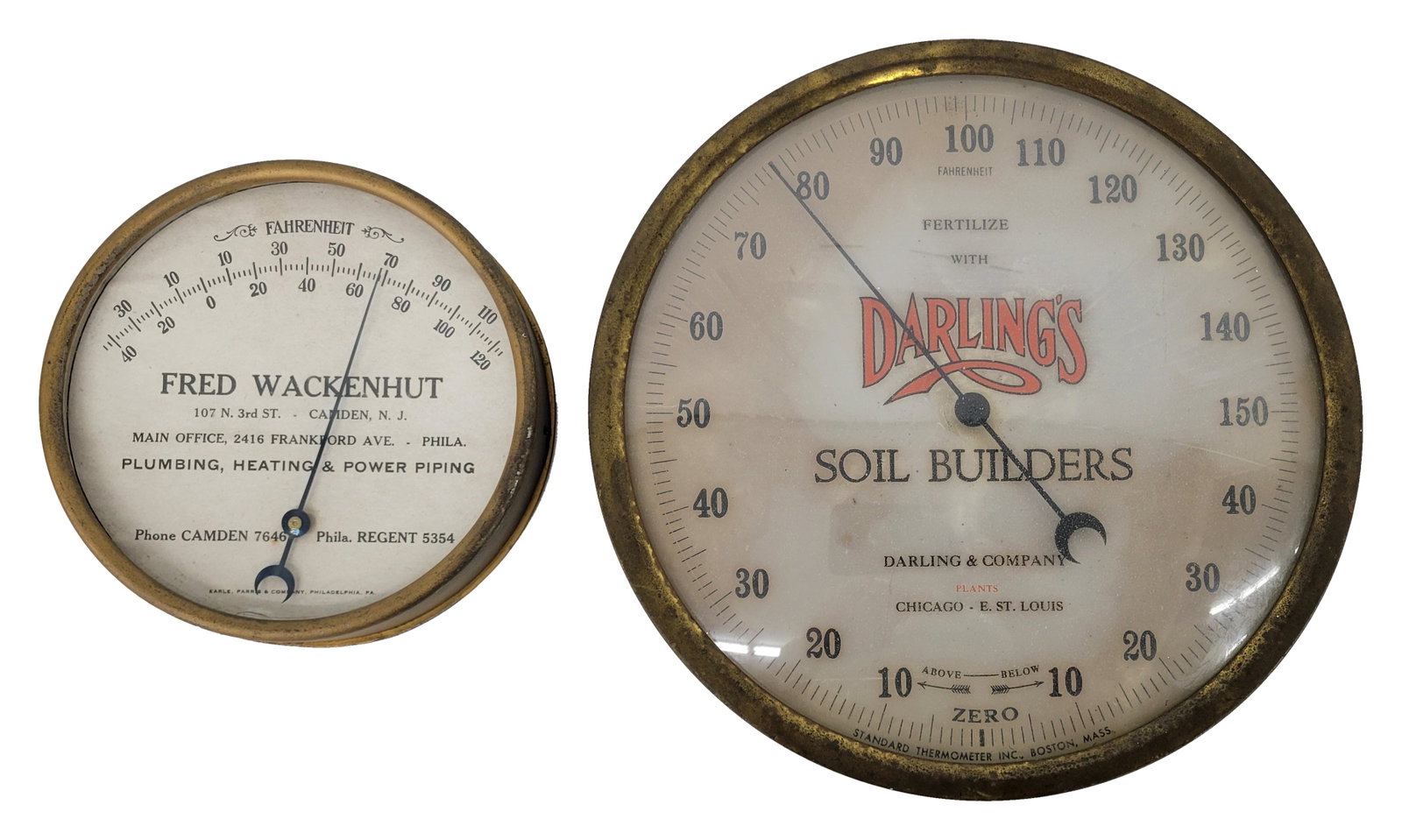 Fred Wackenhut and Darling's Soil Builders Round Thermometers: Lot includes two working thermometers with metal cans and glass faces. The 9" Darling's thermometer has typical wear and the interior advertising face has discoloration. The 6" Fred Wackenhut
