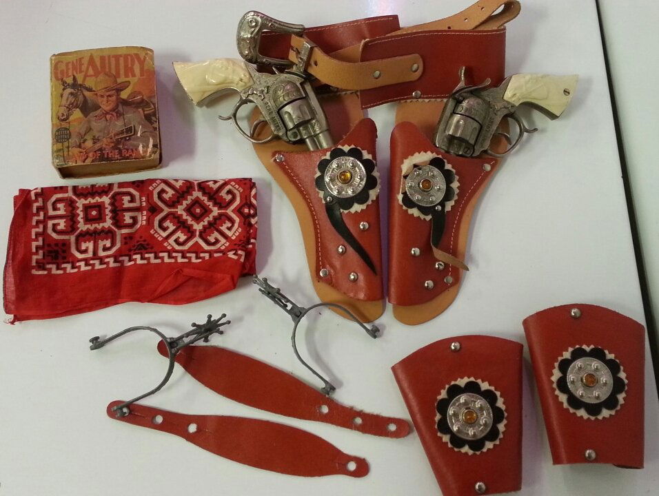 Gene Autry Cowboy Toy Gun & Holster Set: 1930's Gene Autry little big book, Gene Autry cap guns with jeweled holster and arm bands. Spurs and red handkerchief.