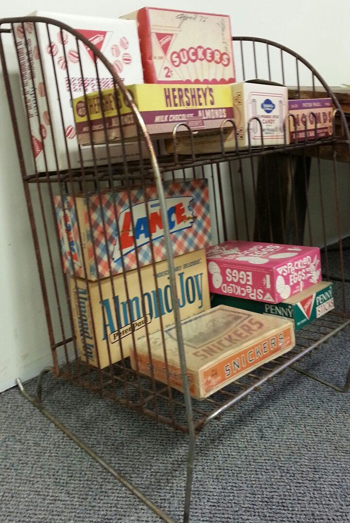 Vintage Country store rack with vintage candy boxes: Curved metal rack with two shelves. Comes with 10 vintage candy store boxes including Snickers, Almond Joy, Lance, Hershey's, Tom's Speckled eggs, Mounds & stick candy.