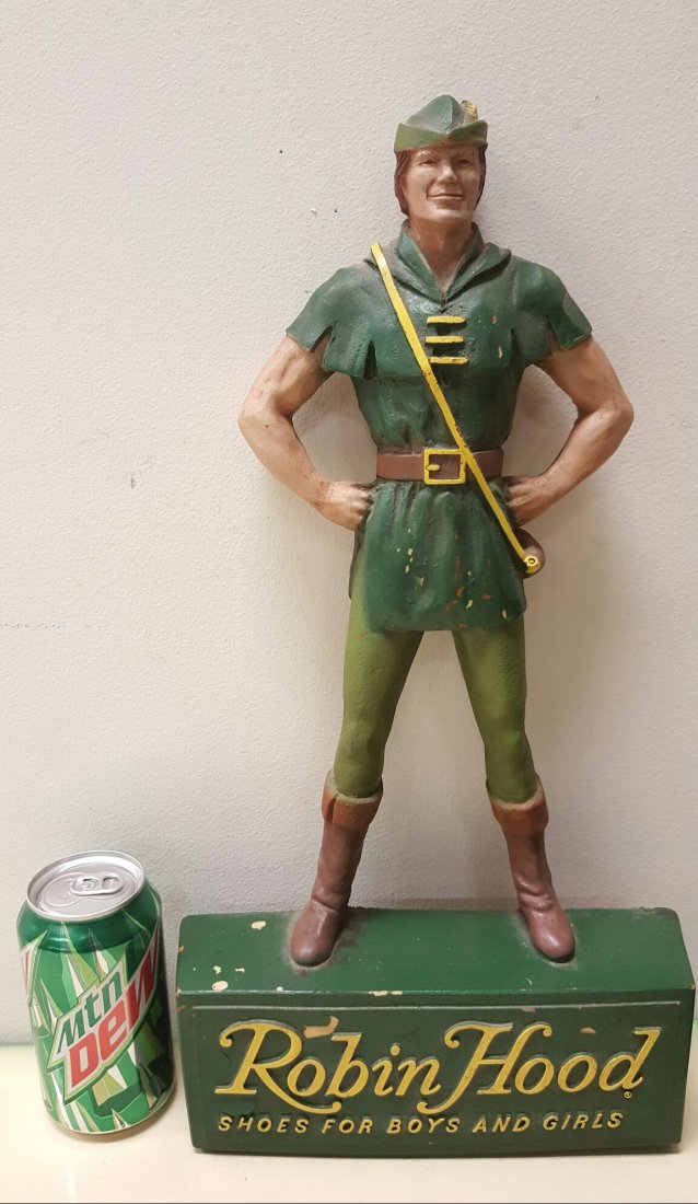 "Robin Hood Shoes For Boys And Girls" Store Display: 9.5"w x 17.5"h x 2.5"d Detailed store display with hat, facial features, belt, buckle, clothes, boots, and lettering on the bottom. The back has a hook for hanging or can be display on a counter. Vint
