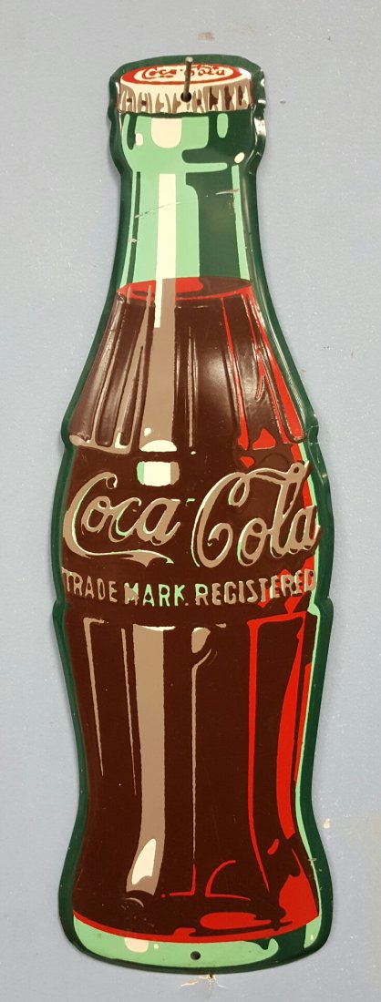 1947 Die Cut Coca Cola Bottle Advertising Sign: 16.75" Coca Cola bottle sign. A-M 10-47 printed at the bottom. There is a scratch across the neck of the bottle otherwise nice condition with minor scuffs.
