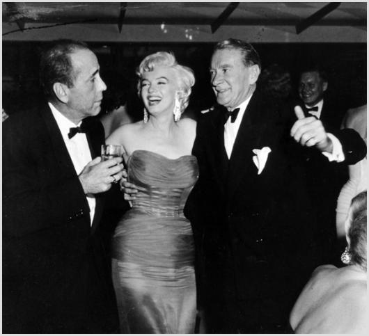 Marilyn Monroe, Bogart,Webb Photo by Sam Shaw: Description of image: Marilyn Monroe with actors Humphrey Bogart and Clifton Webb at the party given in her honor by Charles Feldman, at Romanoff's restaurant, Los Angeles, 1954. The legendary Humphre