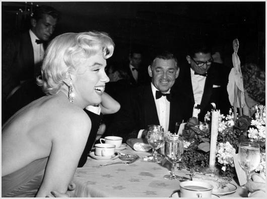 Marilyn Monroe and Clark Gable Photo by Sam Shaw: Description of image: Marilyn Monroe and Clark Gable, with Sidney Skolsky in the background, at a party in Marilyn Monroe's honor at her favorite restaurant, Romanoff's in Los Angeles, CA, 1954. On th