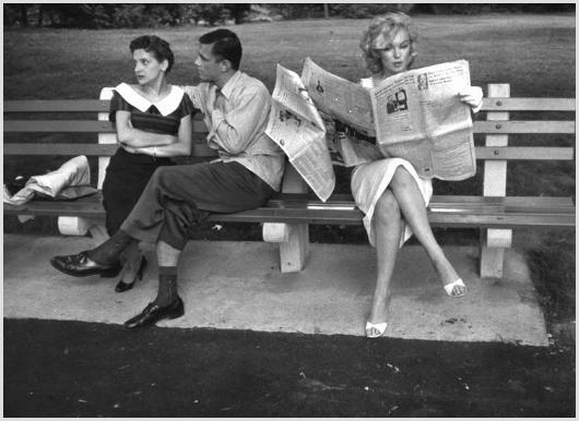 Marilyn Monroe in Central Park #2 Photo by Sam Sh: Description of image: Marilyn Monroe sitting on a bench, next to a couple in New York's Central Park, while reading The New York Times, 1956. Sam Shaw created an artistic image by referring to an acto