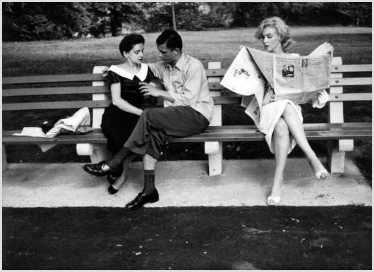 Marilyn Monroe in Central Park #3 Photo by Sam Sh: Description of image: Marilyn Monroe sitting on a bench, next to a couple in New York's Central Park, while reading The New York Times, 1956. Sam Shaw created an artistic photo by referring to an acto