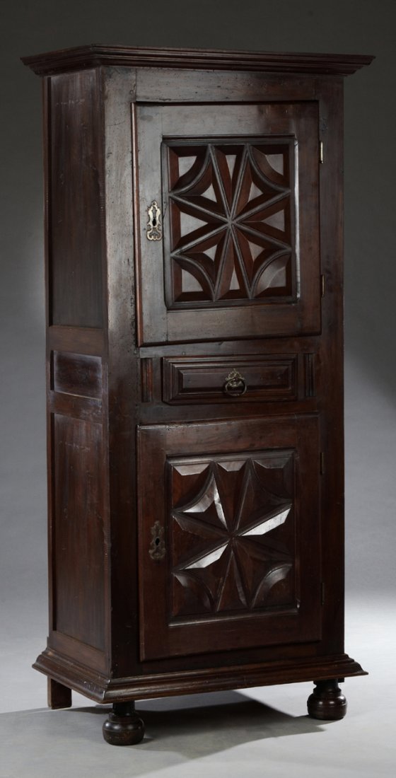 French Louis XIII Style Carved Walnut Homme Debout, mid: French Louis XIII Style Carved Walnut Homme Debout, mid 19th c., the stepped cornice over a relief carved cupboard door with a short iron escutcheon and iron hinges, over a drawer above a like carved 