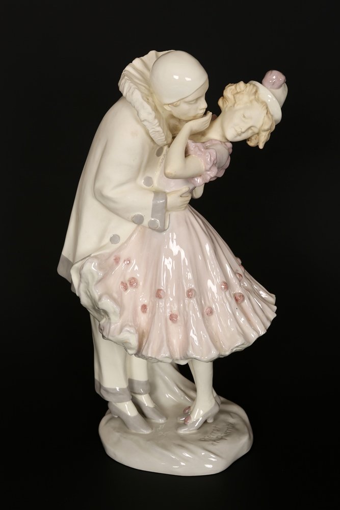An early 20th Century faience figural lamp base: An early 20th Century faience figural lamp base, modelled as Pierrot and Pierrette, signed Podany, blue printed Vienna Faience Schauer factory mark. 43.5cm