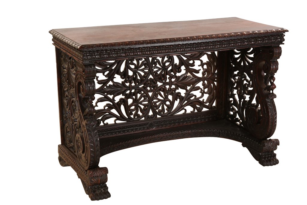 An Anglo-Indian rosewood console table: An Anglo-Indian rosewood console table, 19th Century, the rectangular top with leaf-carved edge over a carved frieze, the fret carved sides and back with large S-scrolls, raised on a gadrooned plinth 