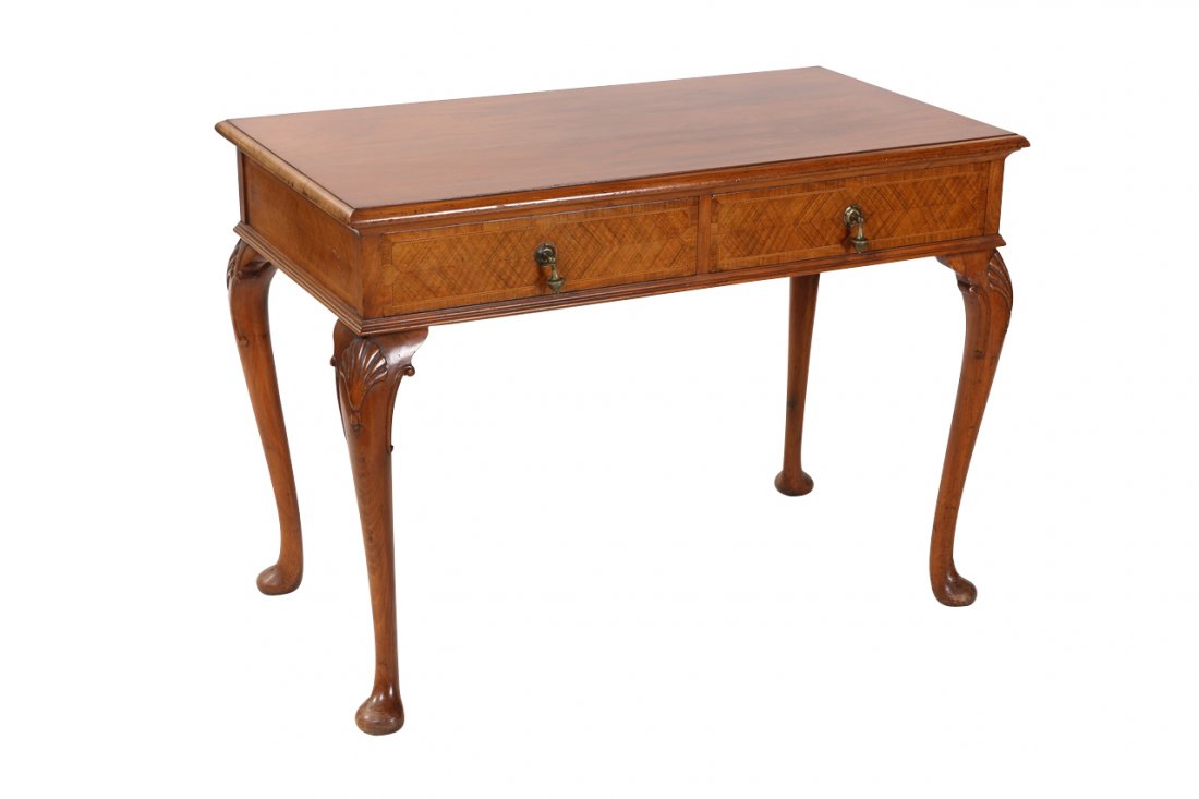 A George I style walnut serving table: A George I style walnut serving table, the moulded rectangular top above a pair of crossbanded and inlaid drawers, raised on shell capped cabriole legs terminating in pads. 77cm by 107cm by 58cm