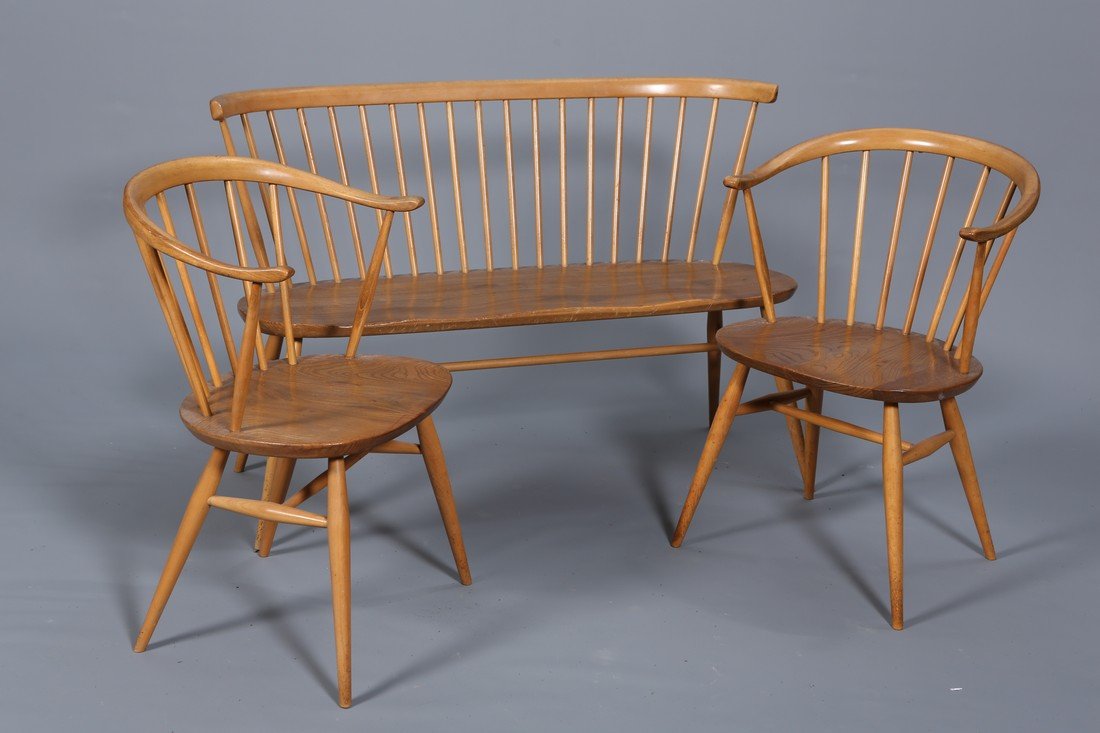 ERCOL A VINTAGE ELM BENCH AND A PAIR OF COW HORN: ERCOL A VINTAGE ELM BENCH AND A PAIR OF COW HORN CHAIRS, each raised on splayed legs and with spindle back.