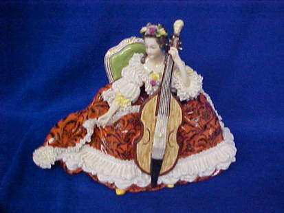 Early Volkstedt Dresden porcelain figure lady w/mu: Early Volkstedt Dresden porcelain figure lady w/musical instrument. Musical instrument has a man head at top. Dresden laced edges around her dress. Lady sitting in a beautiful French chair. Great cond