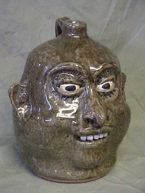 Lanier Meaders Face Jug.: Lanier Meaders Face Jug. Rare jug w/incised eye lashes on top and bottom of eyes. With Kolin teeth. Good condition with no damage w/exciption of a kilm crack 1-1/2"long. Does not distract from value o