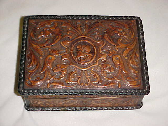 Leather decorated jewerly box w/removable tray.: Leather decorated jewerly box w/removable tray. Dates around the 1930's 40's. Has 4 brass feet, original lock but no key. Removable tray insert. Great tooled leather detail. Good conditon. Measures 3"