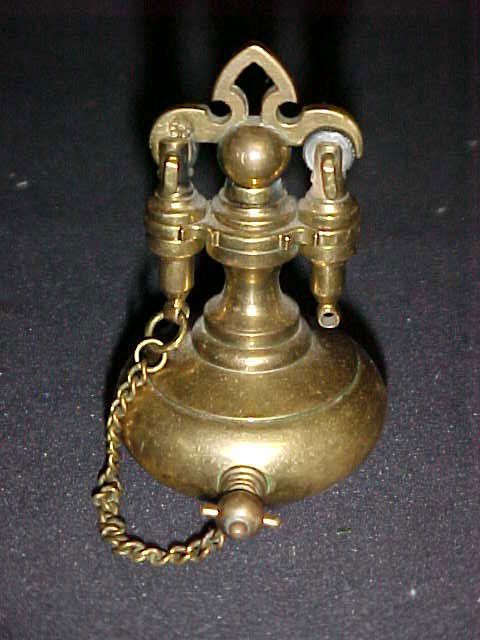 Decorative early brass cigarette lighter.: Decorative early brass cigarette lighter. Made of solid brass, has a chain attached to the fille cap on tank, top opens to the wheel strike lighter. Good patina to the brass. Has a star style marking