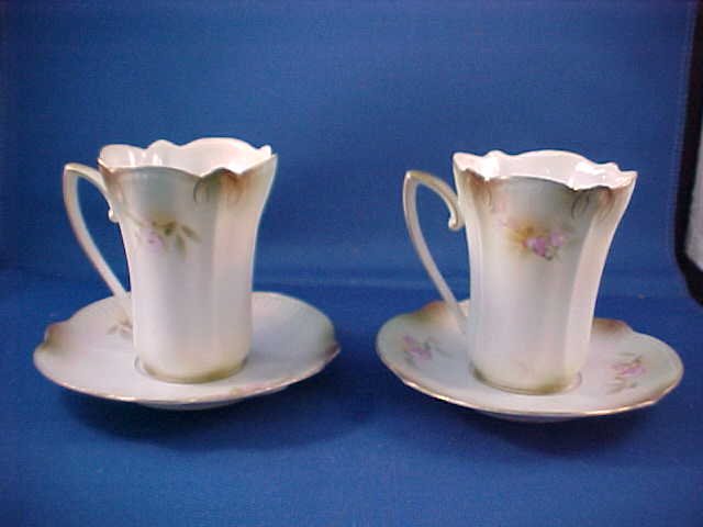 Pair R.S. Prussia floral decorated cup & saucers.: Pair R.S. Prussia floral decorated cup & saucers. Possible from a chocolate set. Pair floral decorations. Good condition w/markings. Measures 4"tall x 4-3/4"wide.