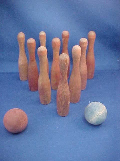 Turned wooden bowling game: Turned wooden bowling game. 10 pins and 2 balls. Each pin measures 4-1/2"H x 1" round. Each bowling ball measures 1-1/2" round
