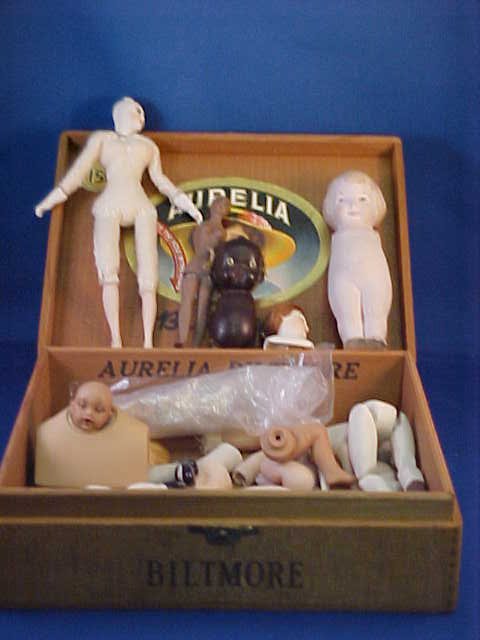 Wooden cigar box of early porcelain/ceramic doll parts: Wooden cigar box of early porcelain/ceramic doll parts.