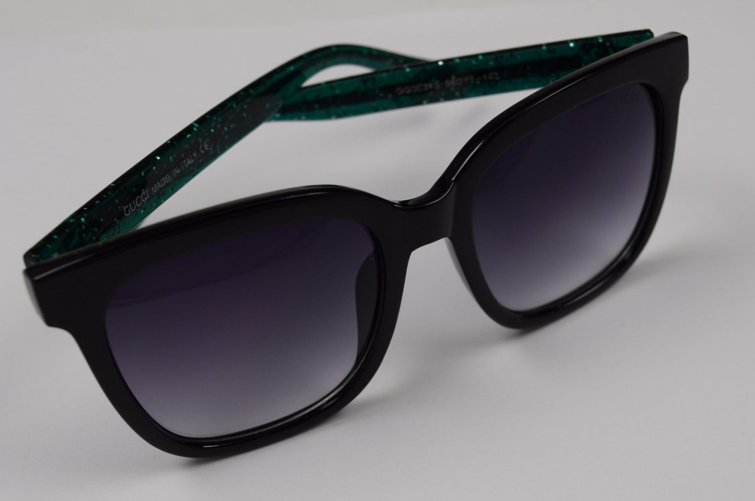 Gucci Sunglasses: Gucci issued womans black sunglasses with green and red accent