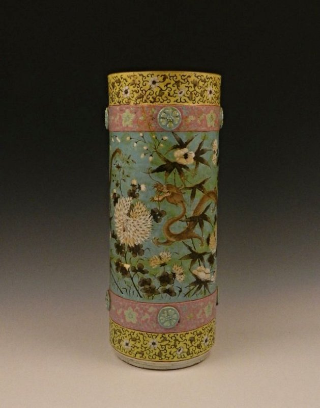 Chinese Export Molded Porcelain Umbrella Stand: Of cylindrical form with molded floral bosses, decorated in famille rose enamels with a continuous scene of rampant dragons among asters and peonies on a turquoise ground Measuring: 18 inches in total