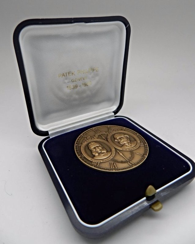 Patek Philippe Anniversary Coin: An original circa 1989 limited production Patek Philippe 150th anniversary coin With an image of Jean Adrien Philippe & Antoine de Patek Measures: 1 1/2 inches Original box included