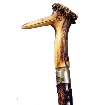 Viennese Folk Cane-C. 1890-A carved stag horn pipe: Viennese Folk Cane-C. 1890-A carved stag horn pipe for a handle, the beak is a stem, metal collar, twig spur shaft and a metal ferrule-O.L. 32 ½"-$150-$250