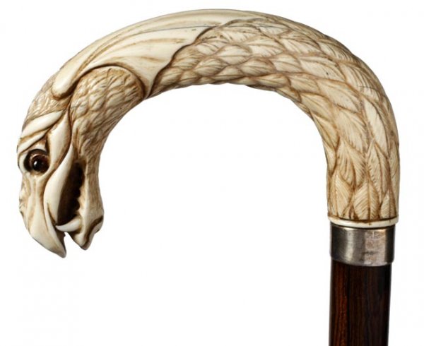 Ivory Dragon Dress Cane: Ivory Dragon Dress-Circa 1890-A carved dragon with two color glass eyes, fierce teeth, silver collar, rosewood shaft and a horn ferrule-H. 4 ¼" x 3", O.L. 36"-$500-$700